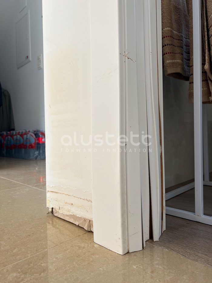 Detalle de puerta hinchada por humedad en la parte inferior